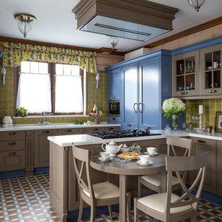 Modelo de cocina ecléctica, de tamaño medio, cerrada, con fregadero de doble seno, armarios con paneles con relieve, encimera de acrílico, salpicadero gris, salpicadero de azulejos de cerámica, electrodomésticos de acero inoxidable y península