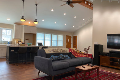 Modelo de sala de estar actual con suelo laminado y vigas vistas