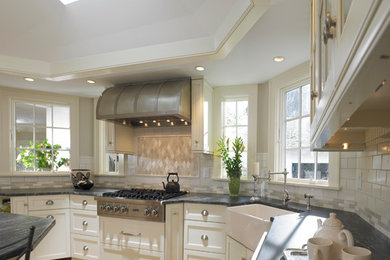 Eat-in kitchen - large cottage u-shaped light wood floor eat-in kitchen idea in Boston with a farmhouse sink, recessed-panel cabinets, white cabinets, beige backsplash, subway tile backsplash, an island and stainless steel appliances