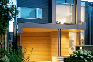 Design ideas for a contemporary three-storey exterior in Toronto with mixed siding.
