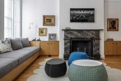 Example of a transitional open concept light wood floor family room design in Boston with white walls, a standard fireplace and a wall-mounted tv