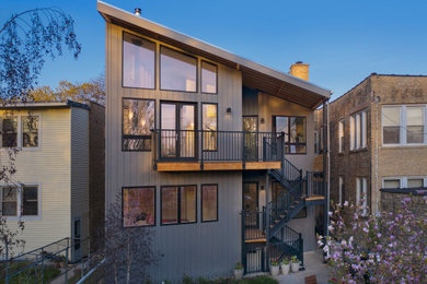 Esempio della facciata di una casa grigia contemporanea a due piani di medie dimensioni con rivestimento con lastre in cemento, copertura in metallo o lamiera, tetto grigio e pannelli sovrapposti