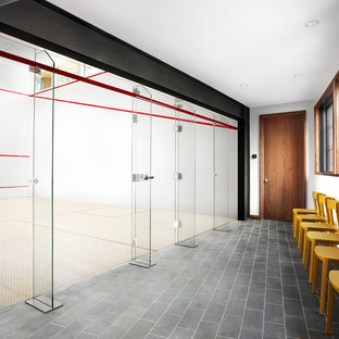 サンフランシスコの巨大なモダンスタイルのおしゃれな室内コート (白い壁、ラミネートの床、茶色い床) の写真