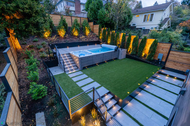 Large minimalist backyard rectangular aboveground pool landscaping photo in Seattle with decking