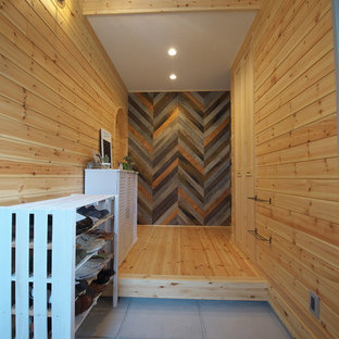 大阪の中サイズの片開きドアカントリー風おしゃれな玄関ホール (コンクリートの床、グレーの床、オレンジの壁、白いドア) の写真