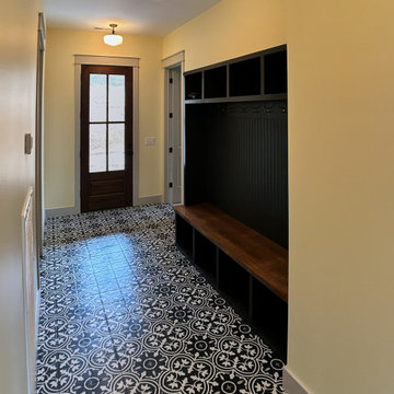 Stylish Entryway Mudroom with Bold Patterned Tile and Custom Storage