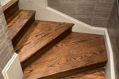 ニューヨークにある小さなトラディショナルスタイルのおしゃれなかね折れ階段 (木の蹴込み板、木材の手すり) の写真