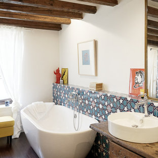 Idées déco pour une grande salle de bain principale campagne avec un placard sans porte, des portes de placard en bois clair, une baignoire indépendante, une douche à l'italienne, un WC suspendu, un carrelage bleu, des carreaux de céramique, un mur blanc, un sol en bambou, un lavabo posé, un plan de toilette en bois, un sol marron, aucune cabine et un plan de toilette marron.