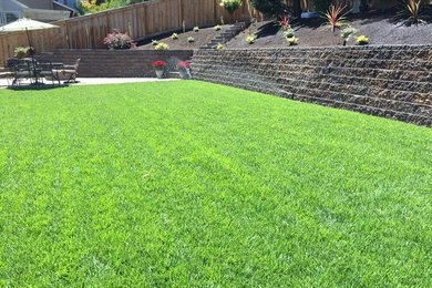 Inspiration for a large traditional full sun backyard brick retaining wall landscape in Portland.