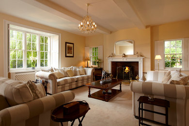 Inspiration for a mid-sized traditional living room in Other with carpet and a wood fireplace surround.