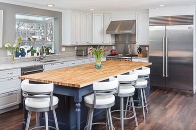 Inspiration for a large transitional l-shaped vinyl floor and brown floor eat-in kitchen remodel in Other with an undermount sink, raised-panel cabinets, white cabinets, quartz countertops, white backsplash, ceramic backsplash, stainless steel appliances, an island and white countertops