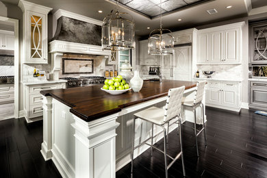Elegant dark wood floor kitchen photo in Los Angeles with raised-panel cabinets, white cabinets, multicolored backsplash, mosaic tile backsplash, stainless steel appliances and an island