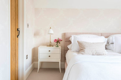 Inspiration for a mid-sized country guest bedroom in Buckinghamshire with pink walls, carpet and beige floor.