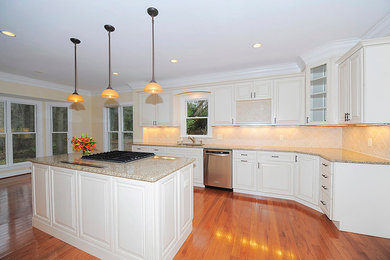 Large elegant l-shaped medium tone wood floor eat-in kitchen photo in DC Metro with a drop-in sink, raised-panel cabinets, white cabinets, granite countertops, cement tile backsplash, stainless steel appliances and an island