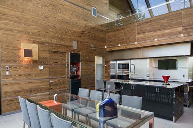 Example of a trendy ceramic tile and gray floor kitchen design in Montreal with black cabinets, marble countertops, gray backsplash and an island