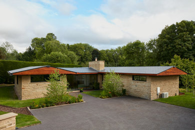 Diseño de fachada de casa multicolor y gris retro grande de una planta con revestimiento de madera y tejado de teja de barro
