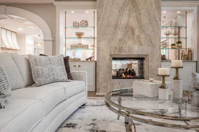 Living room - transitional open concept light wood floor living room idea in Cleveland with beige walls, a two-sided fireplace and a stone fireplace
