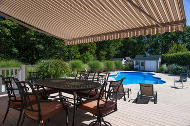 На фото: бассейн среднего размера, произвольной формы на заднем дворе в современном стиле с домиком у бассейна и настилом с