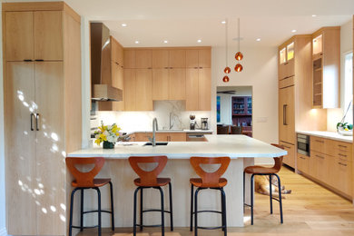 Mid-sized trendy u-shaped light wood floor and beige floor enclosed kitchen photo in San Francisco with an undermount sink, flat-panel cabinets, light wood cabinets, quartz countertops, multicolored backsplash, quartz backsplash, stainless steel appliances, a peninsula and multicolored countertops