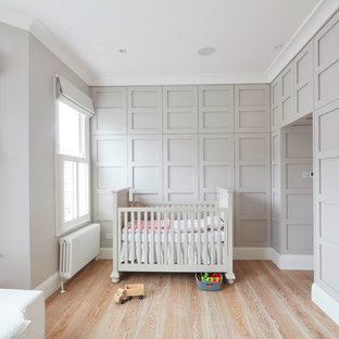 Großes Klassisches Schlafzimmer mit grauer Wandfarbe, braunem Holzboden und Kaminofen in London