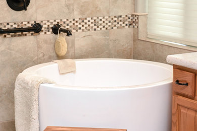 Design ideas for a large modern master bathroom in Phoenix with raised-panel cabinets, brown cabinets, a japanese tub, a corner shower, a two-piece toilet, beige tile, ceramic tile, beige walls, porcelain floors, a drop-in sink, quartzite benchtops, beige floor and a hinged shower door.