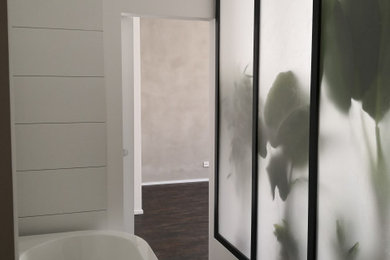Kleines Badezimmer mit Badewanne in Nische, Vinylboden, braunem Boden und Pflanzen in Berlin