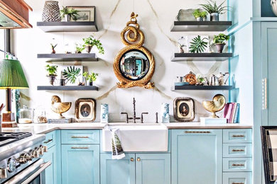 Example of a mid-sized eclectic u-shaped medium tone wood floor and brown floor eat-in kitchen design in Atlanta with a farmhouse sink, shaker cabinets, quartzite countertops, white backsplash, porcelain backsplash, stainless steel appliances, no island and blue cabinets
