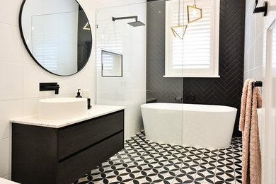 Inspiration for a modern wet room bathroom in Brisbane with dark wood cabinets, a freestanding tub, a one-piece toilet, black tile, ceramic tile, white walls, ceramic floors, a vessel sink, engineered quartz benchtops, an open shower and white benchtops.