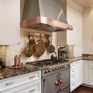 Aménagement d'une petite arrière-cuisine classique en U avec un évier encastré, un placard à porte plane, des portes de placard blanches, un plan de travail en granite, une crédence blanche, une crédence en carrelage de pierre, un électroménager en acier inoxydable, un sol en bois foncé et aucun îlot.