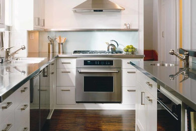 Trendy l-shaped dark wood floor eat-in kitchen photo in Minneapolis with an undermount sink, flat-panel cabinets, white cabinets, stainless steel countertops, metallic backsplash, stainless steel appliances, metal backsplash and an island