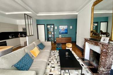 Cette photo montre un salon tendance de taille moyenne et ouvert avec parquet clair, une cheminée standard et un téléviseur fixé au mur.