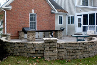 Example of a mid-sized transitional backyard concrete paver patio design in Nashville with no cover