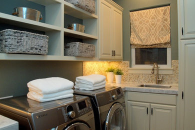Inspiration for a mid-sized transitional l-shaped dedicated laundry room remodel in Austin with an undermount sink, raised-panel cabinets, white cabinets, marble countertops, green walls and a side-by-side washer/dryer