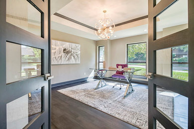 Example of a large trendy freestanding desk dark wood floor and brown floor study room design in Oklahoma City with beige walls