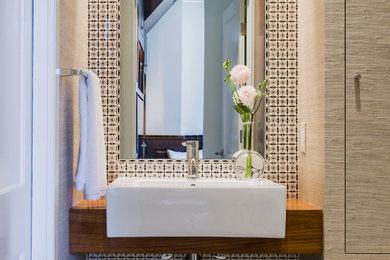Small contemporary powder room in Boston with a vessel sink, wood benchtops, multi-coloured tile, medium wood cabinets, ceramic tile, beige walls, mosaic tile floors, grey floor and brown benchtops.