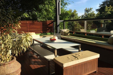 This is an example of a mid-sized contemporary backyard patio in Sydney with decking and a roof extension.