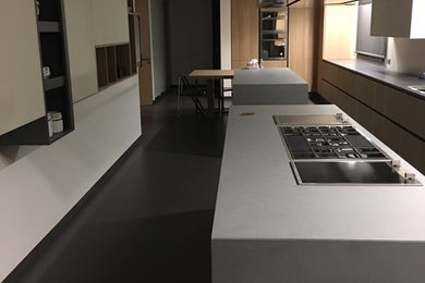 Example of a large minimalist galley open concept kitchen design in Other with light wood cabinets, concrete countertops, black backsplash, stainless steel appliances and two islands