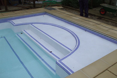 Klassischer Pool hinter dem Haus in individueller Form mit Natursteinplatten in Oxfordshire