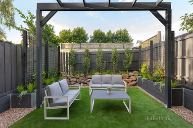 Mid-sized modern backyard full sun formal garden in Melbourne with a container garden and gravel for summer.