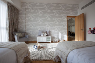 Photo of a large contemporary gender-neutral kids' bedroom for kids 4-10 years old in London with grey walls and carpet.
