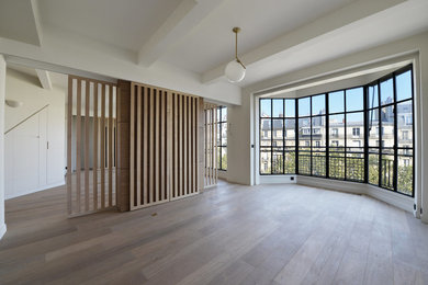 Exemple d'un grand salon tendance ouvert avec parquet clair et un téléviseur dissimulé.