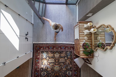 Entryway - large eclectic slate floor and gray floor entryway idea in Vancouver with white walls and a glass front door