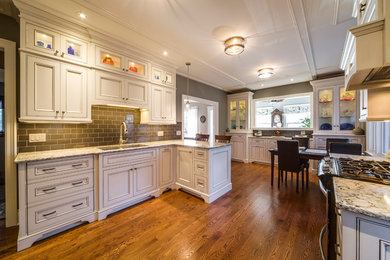 Eat-in kitchen - mid-sized traditional u-shaped dark wood floor and brown floor eat-in kitchen idea in Toronto with an undermount sink, beaded inset cabinets, white cabinets, granite countertops, stainless steel appliances and glass tile backsplash