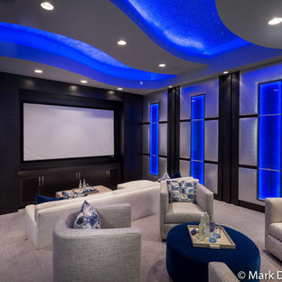 Réalisation d'une petite salle de cinéma design fermée avec un mur beige, moquette et un écran de projection.