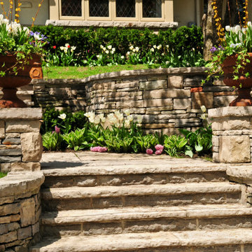 Simple raised paver and synthetic block patio, steps & seating wall
