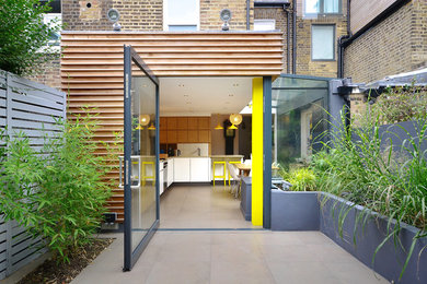 Design ideas for a contemporary rear house exterior in London with three floors and mixed cladding.