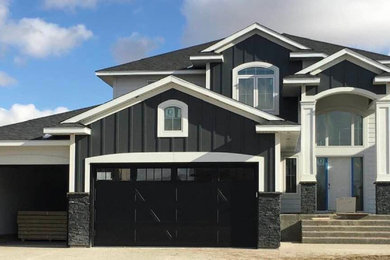 Black two-story house exterior photo in Other with a black roof