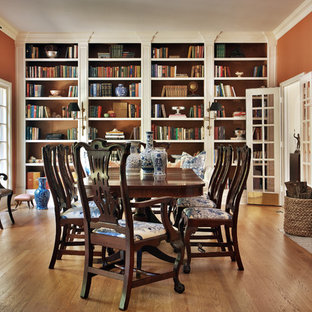 Geschlossenes, Großes Klassisches Esszimmer mit oranger Wandfarbe, braunem Holzboden, Kamin, gefliestem Kaminsims und braunem Boden in New York