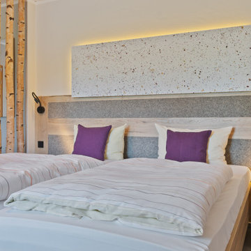 Schlafzimmer mit Raumteiler aus Borkenstämmen