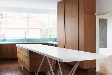 This is an example of a contemporary l-shaped kitchen in Melbourne with flat-panel cabinets, medium wood cabinets, blue splashback, stainless steel appliances and with island.